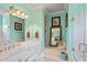 Light-filled bathroom featuring white cabinets, tile flooring and mint green paint at 440 Old Homestead Trl, Johns Creek, GA 30097