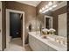 Bathroom with double sinks, white cabinets, and decorative lighting and wallpaper at 440 Old Homestead Trl, Johns Creek, GA 30097