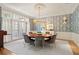 Formal dining room featuring custom wallpaper, elegant lighting, and a round table with seating for sophisticated entertaining at 440 Old Homestead Trl, Johns Creek, GA 30097
