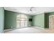 Empty room with green walls, a large window, and neutral carpet with a mounted television at 440 Old Homestead Trl, Johns Creek, GA 30097