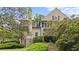 Elegant stone and stucco exterior with lush landscaping and mature trees, highlighting the home's architectural beauty at 440 Old Homestead Trl, Johns Creek, GA 30097