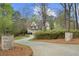 Stately stone home with a circular driveway and mature landscaping at 440 Old Homestead Trl, Johns Creek, GA 30097