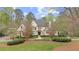 Elegant stone home with manicured lawn and mature trees creates a welcoming curb appeal at 440 Old Homestead Trl, Johns Creek, GA 30097