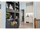 Hallway with built-in shelving, wood floors, and a view of a butler's pantry with white cabinets and a sink at 440 Old Homestead Trl, Johns Creek, GA 30097