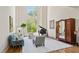 Elegant living room with a baby grand piano, tall windows, and classic hardwood floors at 440 Old Homestead Trl, Johns Creek, GA 30097
