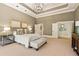 Spacious main bedroom featuring tray ceilings, chandelier, and neutral color palette at 440 Old Homestead Trl, Johns Creek, GA 30097