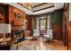 Office space with wooden walls, fireplace, built-in shelving, and light filled window with chairs at 440 Old Homestead Trl, Johns Creek, GA 30097