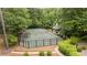 Private tennis court surrounded by lush greenery with viewing gazebo and fenced enclosure offers recreation and relaxation at 440 Old Homestead Trl, Johns Creek, GA 30097