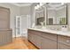 Dual sink bathroom featuring granite counters, hardwood floors, and neutral paint at 8385 Sentinae Chase Dr, Roswell, GA 30076