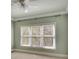 Light-filled bedroom with a large window featuring blinds, neutral paint, carpet, and detailed trim at 8385 Sentinae Chase Dr, Roswell, GA 30076