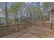 A backyard deck with wood finish overlooks the wooded lot at 8385 Sentinae Chase Dr, Roswell, GA 30076