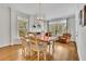 Dining room with large windows, hardwood floors, and decorative chandelier at 8385 Sentinae Chase Dr, Roswell, GA 30076