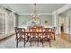 Elegant dining room features hardwood floors, chandelier, and wainscoting at 8385 Sentinae Chase Dr, Roswell, GA 30076