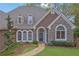 Attractive home featuring stone accents, arched windows, dormers, and lush landscaping at 8385 Sentinae Chase Dr, Roswell, GA 30076