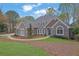 Stunning stone and stucco home with arched windows, dormers, landscaped yard and inviting pathway at 8385 Sentinae Chase Dr, Roswell, GA 30076