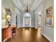 Bright foyer featuring hardwood floors, elegant chandelier, and views into other living spaces at 8385 Sentinae Chase Dr, Roswell, GA 30076