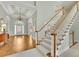 Grand foyer featuring an elegant staircase, chandelier, hardwood floors, and detailed trim at 8385 Sentinae Chase Dr, Roswell, GA 30076