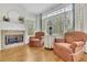 Cozy living room with a fireplace, large windows, and comfortable seating at 8385 Sentinae Chase Dr, Roswell, GA 30076