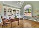 Cozy office featuring custom built-ins, hardwood floors, vaulted ceiling and a large arched window at 8385 Sentinae Chase Dr, Roswell, GA 30076