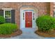 Close up of red front door with brick surround and manicured bushes at 1 N Boundary Nw Pl, Atlanta, GA 30318