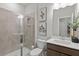 Modern bathroom features a glass shower, neutral tiles, and floating vanity with white countertop and sink at 1455 Auburn Glen Rd, Dacula, GA 30019