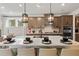 A gourmet kitchen features an island with barstool seating, modern pendant lights, and stainless steel appliances at 1455 Auburn Glen Rd, Dacula, GA 30019