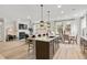 Open-concept living space with kitchen island, dining area, and living room featuring a fireplace at 1455 Auburn Glen Rd, Dacula, GA 30019