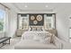 Bright primary bedroom showcases a tray ceiling, stylish wall decor, and a comfortable seating area at 1455 Auburn Glen Rd, Dacula, GA 30019