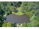 Overhead shot of a serene lake surrounded by lush trees with walking paths and a small grassy area at 201 Rippling Nw Dr, Marietta, GA 30064