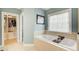 Serene bathroom with soaking tub, large window, and walk-in closet at 201 Rippling Nw Dr, Marietta, GA 30064