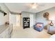 A quaint bedroom with a ceiling fan, a comfy chair, and neutral carpet at 201 Rippling Nw Dr, Marietta, GA 30064