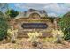 Stone entrance sign for McDaniell Farm surrounded by vibrant green shrubs and flowering plants at 201 Rippling Nw Dr, Marietta, GA 30064