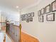 Upstairs hallway featuring wood floors, decorative molding, and a photo gallery wall at 201 Rippling Nw Dr, Marietta, GA 30064