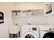 Functional laundry room with shelving, utility sink, and modern appliances at 201 Rippling Nw Dr, Marietta, GA 30064