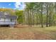 Backyard featuring a deck, lawn area, and wooded surroundings at 530 S Lost Lake Cv, Villa Rica, GA 30180