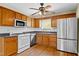 Open kitchen with wood cabinets, stainless steel appliances, and subway tile backsplash at 530 S Lost Lake Cv, Villa Rica, GA 30180
