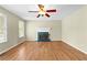 Cozy living room featuring hardwood floors, a fireplace with windows on each side and ceiling fan at 530 S Lost Lake Cv, Villa Rica, GA 30180