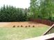 Large backyard featuring a well-kept lawn, privacy fence, and mature trees at 5610 Hollowbrooke Ln, Acworth, GA 30101