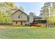 Expansive backyard featuring a deck and a classic tan home exterior with a striking red door at 6040 Carriage Dr, Cumming, GA 30028