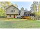 Expansive backyard featuring a deck and a classic tan home exterior with a striking red door at 6040 Carriage Dr, Cumming, GA 30028