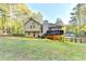 Expansive backyard featuring a deck and a classic tan home exterior at 6040 Carriage Dr, Cumming, GA 30028