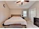 This neutral bedroom features a ceiling fan, bed, and a dresser at 6040 Carriage Dr, Cumming, GA 30028