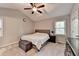 This bedroom is furnished with a bed, bench, ceiling fan, window, and dresser at 6040 Carriage Dr, Cumming, GA 30028