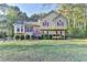 Inviting two-story home with red shutters, manicured bushes, and a well-maintained lawn in a wooded setting at 6040 Carriage Dr, Cumming, GA 30028