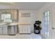 Bright kitchen with white cabinets, stainless steel appliances, tiled floors, and door to the deck at 6040 Carriage Dr, Cumming, GA 30028