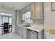 Bright kitchen with stainless steel dishwasher, white cabinets, and tiled floors at 6040 Carriage Dr, Cumming, GA 30028