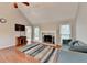 Cozy living room featuring a fireplace, hardwood floors, vaulted ceiling, and great natural lighting at 6040 Carriage Dr, Cumming, GA 30028