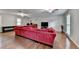 Spacious living room featuring hardwood floors, a large red sectional sofa, and multiple windows at 6040 Carriage Dr, Cumming, GA 30028