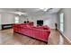 Spacious living room featuring hardwood floors, a large red sectional sofa, and multiple windows at 6040 Carriage Dr, Cumming, GA 30028