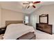 This primary bedroom offers a ceiling fan, neutral walls, a large window, and a dresser with a mirror at 6040 Carriage Dr, Cumming, GA 30028